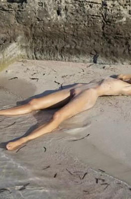 Тощая блондинка на пляже в песке