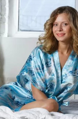 Голая девушка сняла шёлковый халат на кровати